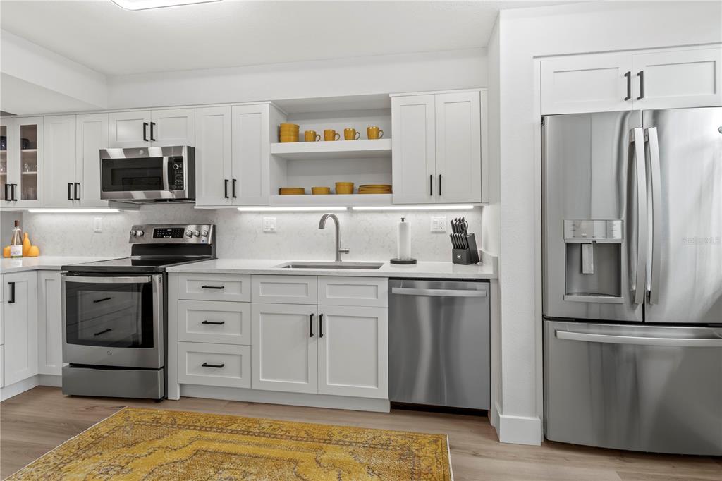 609 Bayport Way, Unit 609 Longboat Key, FL 34228 - Photo 9 of 77 a kitchen with refrigerator cabinets and microwave