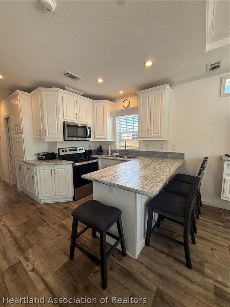 53 Freedom Way Lake Placid, FL 33852 - Photo 11 of 26 a kitchen with kitchen island granite countertop wooden floors appliances and sink