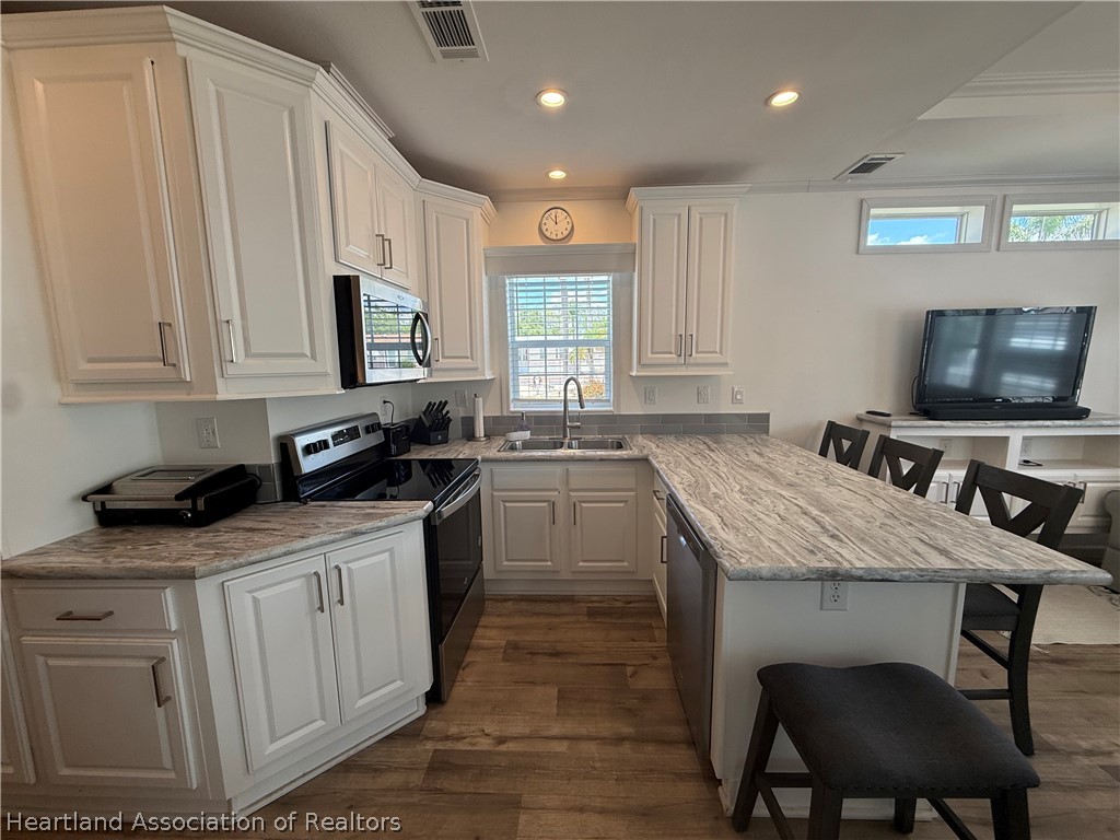 53 Freedom Way Lake Placid, FL 33852 - Photo 14 of 26 a kitchen with granite countertop a sink stove and cabinets