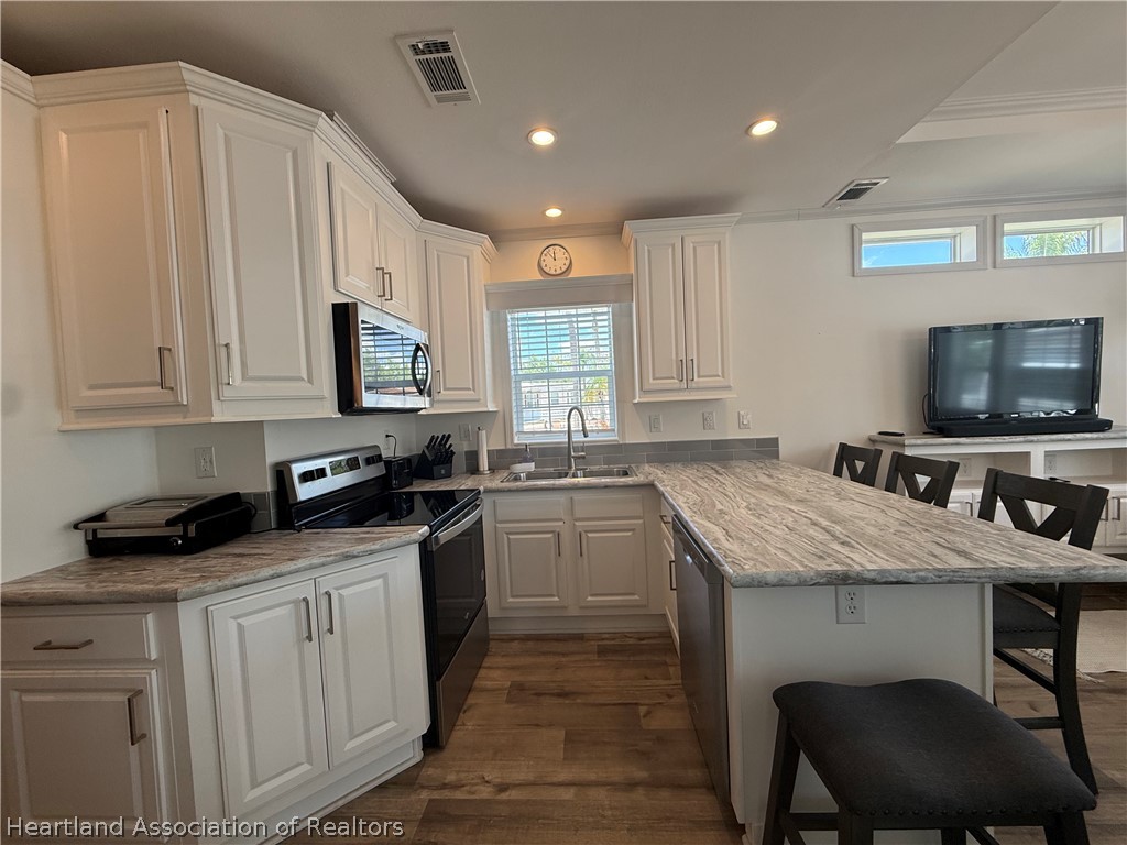 53 Freedom Way Lake Placid, FL 33852 - Photo 9 of 26 a kitchen with granite countertop a stove a sink and a microwave