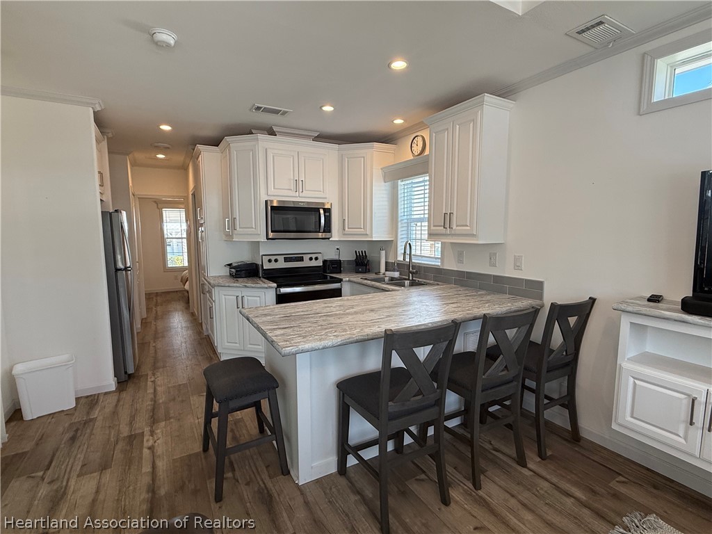 53 Freedom Way Lake Placid, FL 33852 - Photo 10 of 26 a kitchen with kitchen island wooden cabinets and stainless steel appliances