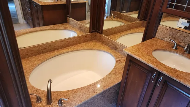 a bathroom with a granite countertop sink and mirror