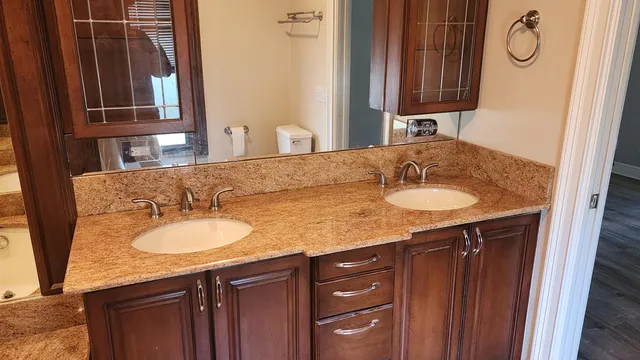 a bathroom with a granite countertop sink and a mirror