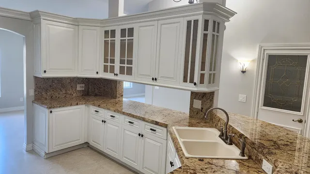 a bathroom with granite countertop a sink and a mirror