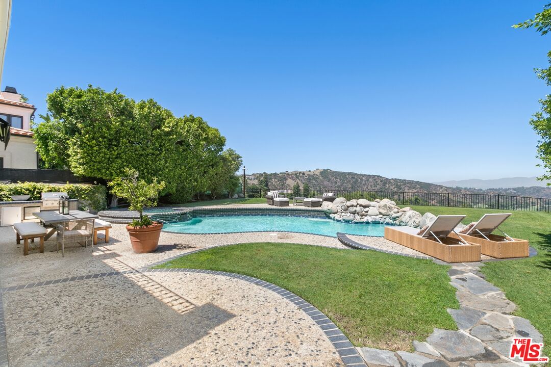 12519 Promontory Road Los Angeles, CA 90049 - Photo 6 of 10 a view of a swimming pool with lounge chairs