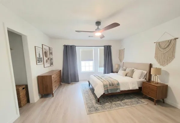a spacious bedroom with a bed and a chandelier