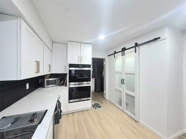 a kitchen with stainless steel appliances a refrigerator sink and microwave