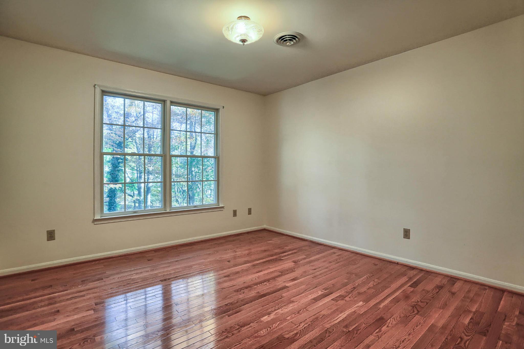 4905 Teen Barnes Road Frederick, MD 21703 - Photo 22 of 30 a view of an empty room with wooden floor and a window
