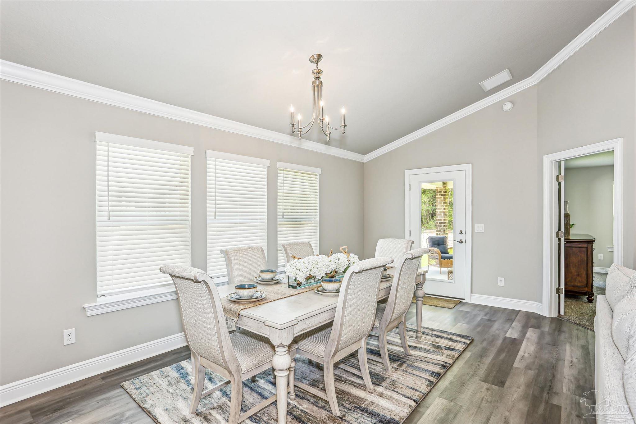 3494 Doyle Hawkins Road Navarre, FL 32566 - Photo 10 of 30 a view of a dining room with furniture window and wooden floor
