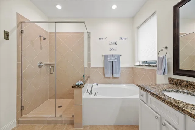 a bathroom with a granite countertop sink a mirror and a bathtub