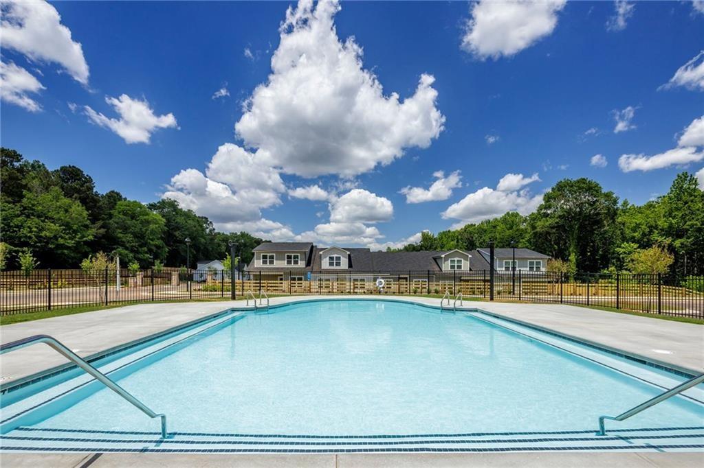 100 Cottage Way, Unit CARAWAY Hampton, GA 30228 - Photo 11 of 44 a view of a swimming pool with a lawn chairs under an umbrella