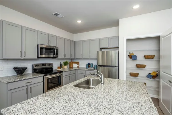 a kitchen with stainless steel appliances granite countertop a sink stove and refrigerator