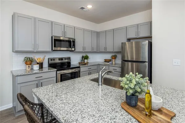 a kitchen with stainless steel appliances granite countertop a refrigerator sink and stove