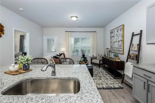a kitchen with a sink a stove and a wooden floor
