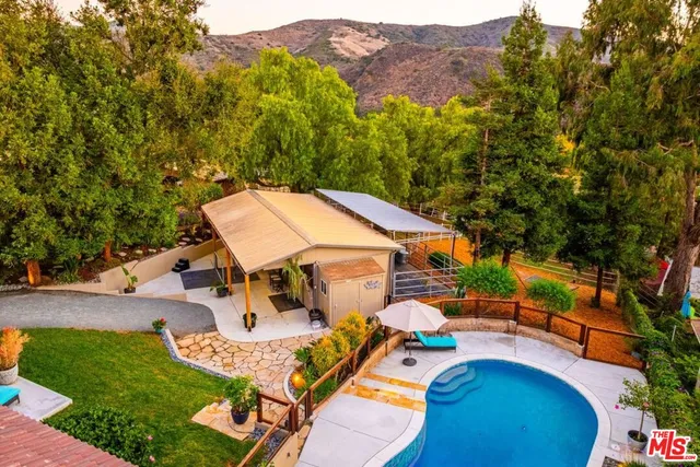 an aerial view of a house with swimming pool garden and patio