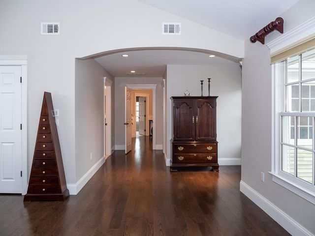 a view of a hallway with wooden floor and stairs