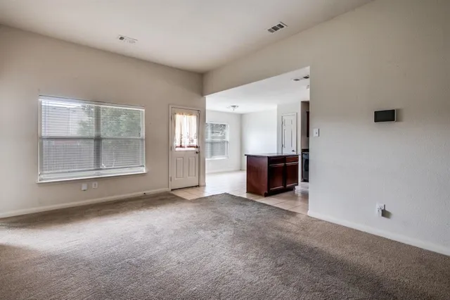 an empty room with a fireplace and window