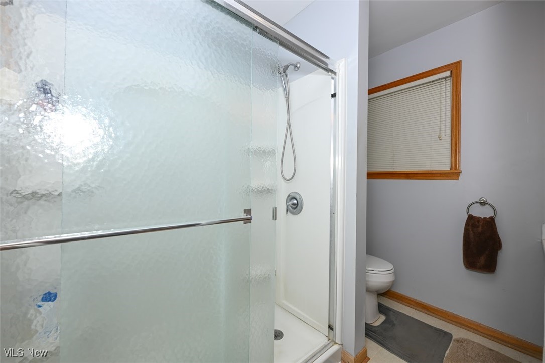 3305 Edington Road Akron, OH 44333 - Photo 21 of 46 Full bathroom featuring toilet, baseboards, and a stall shower