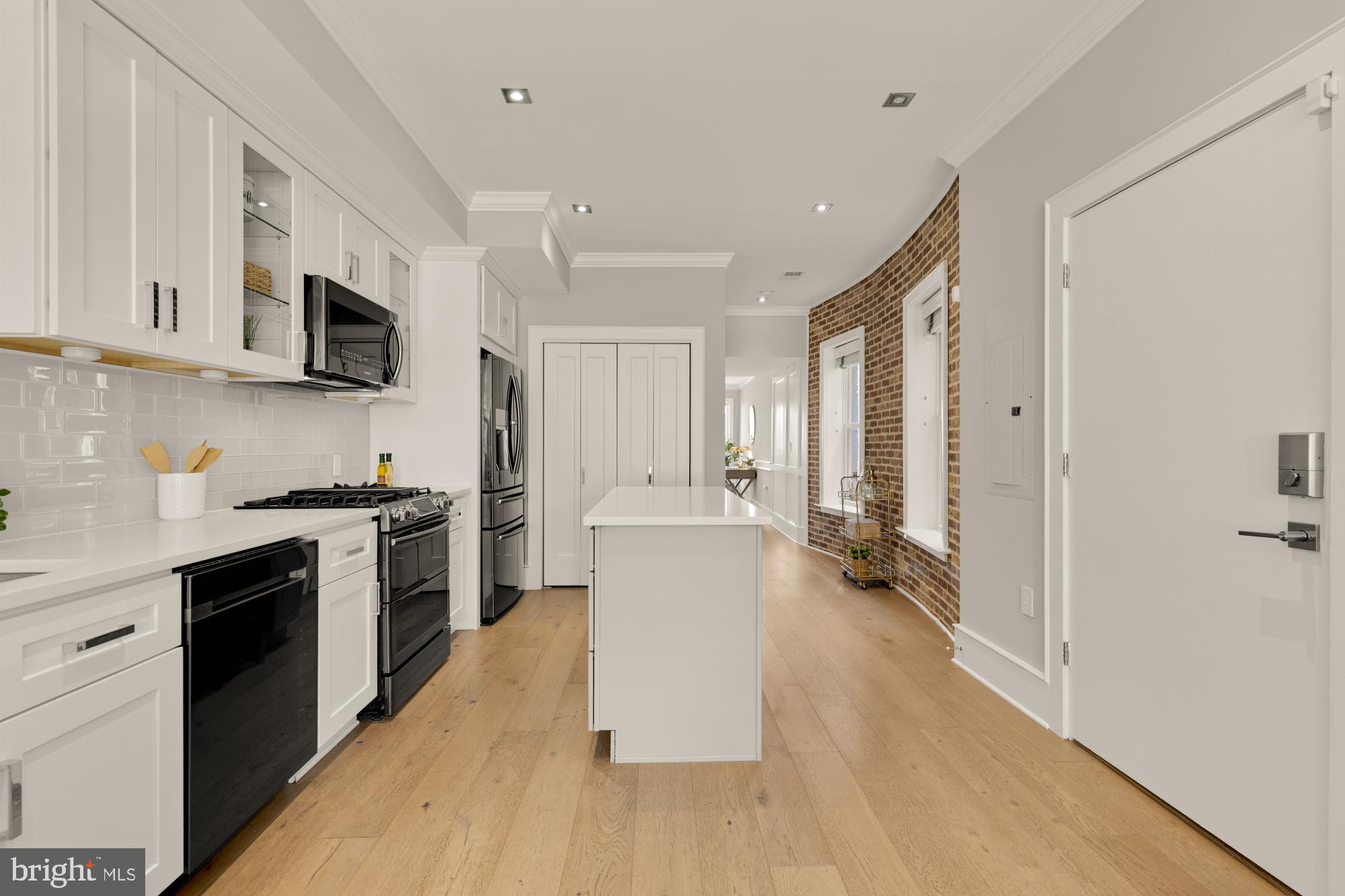 1735 1st Street Northwest, Unit 2 Washington, DC 20001 - Photo 7 of 38 a kitchen with a sink a counter top space stainless steel appliances and cabinets