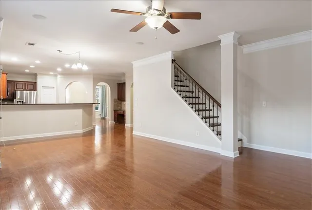 a view of a hallway with wooden floor and a kitchen