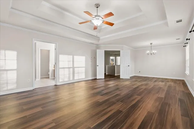 a view of an empty room with window and wooden floor