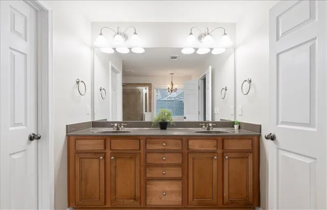 a bathroom with a granite countertop sink a large mirror and a shower
