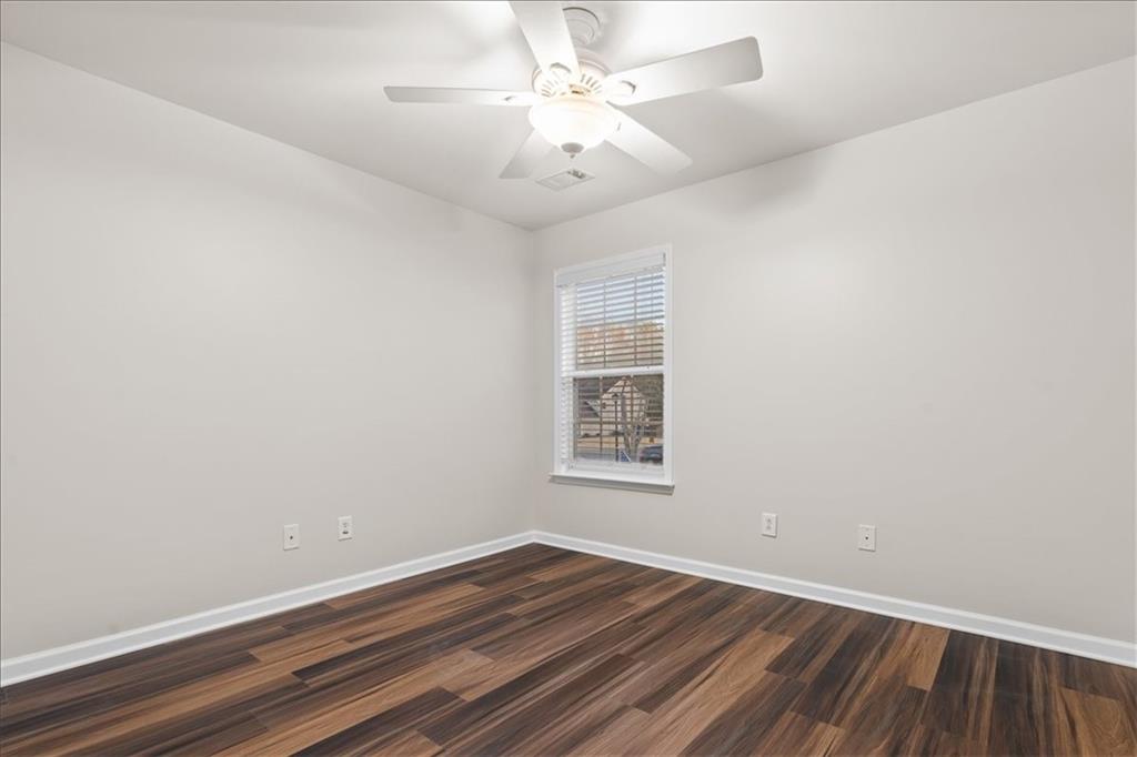 4740 Shiloh Crossing Way Cumming, GA 30040 - Photo 23 of 25 an empty room with wooden floor and windows
