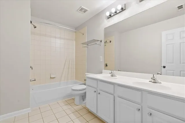 a bathroom with a double vanity sink mirror and toilet