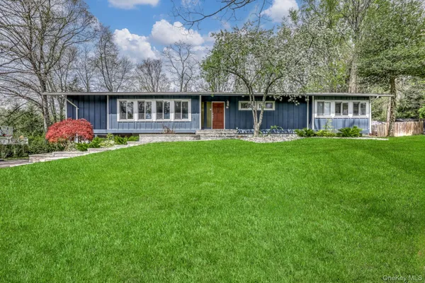 a view of a house with a yard and sitting area