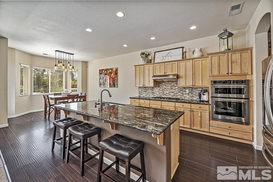 1578 Gemtown Court Reno, NV 89521 - Photo 8 of 25 a kitchen with stainless steel appliances kitchen island granite countertop a stove a sink and a refrigerator