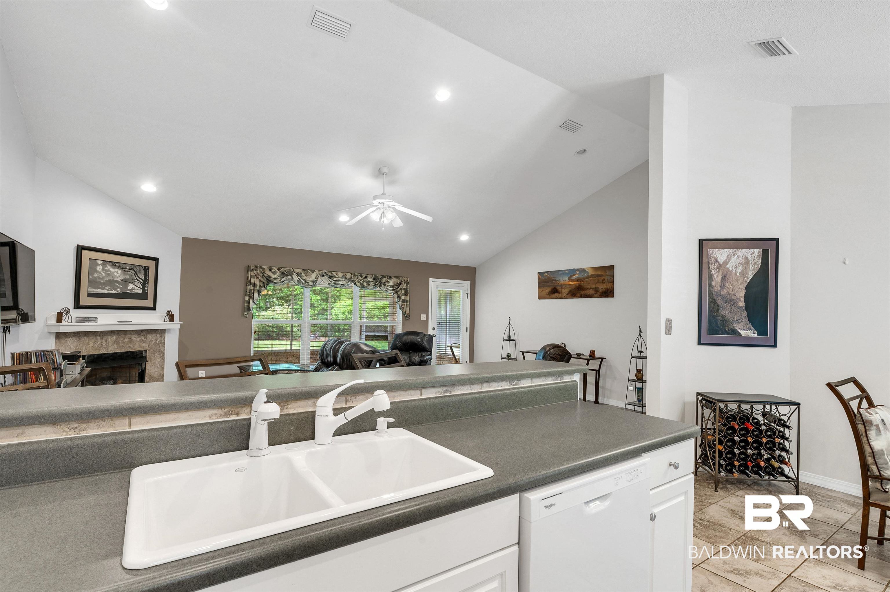 9908 Clarke Ridge Road Foley, AL 36535 - Photo 56 of 56 Kitchen with visible vents, dark countertops, a sink, open floor plan, and white dishwasher
