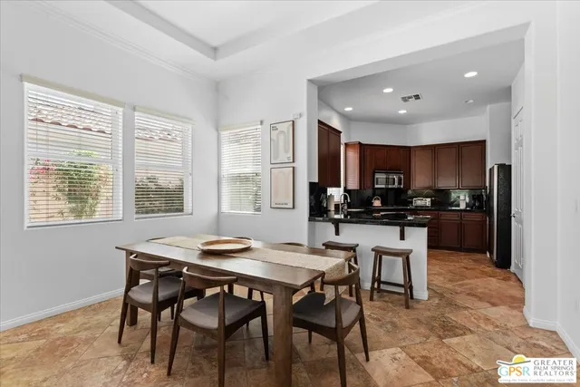 a kitchen with a table chairs refrigerator and cabinets