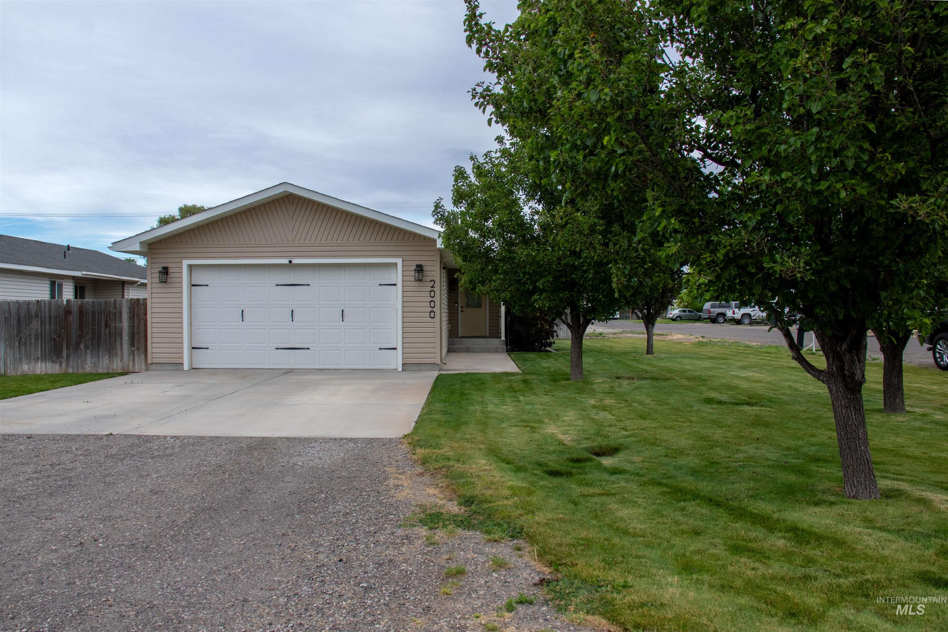 2000 M Street Heyburn, ID 83336 - Photo 15 of 15 Single-story residence featuring light-colored siding, an attached two-car garage with decorative hardware, and a paved driveway