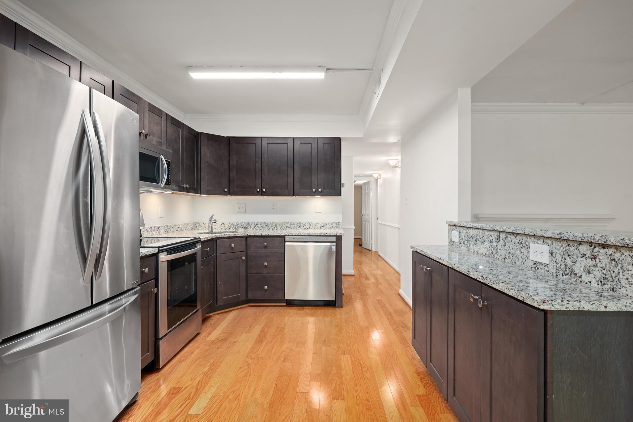 11721 Karbon Hill Court, Unit T2 Reston, VA 20191 - Photo 16 of 31 a kitchen with stainless steel appliances granite countertop a refrigerator a stove and a wooden floors