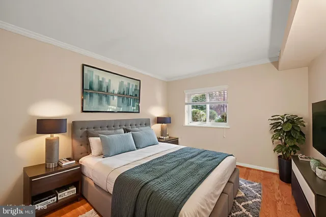a bedroom with a bed and a flat tv screen on a dresser