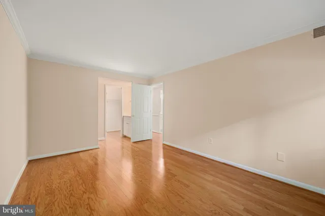 a view of an empty room with wooden floor