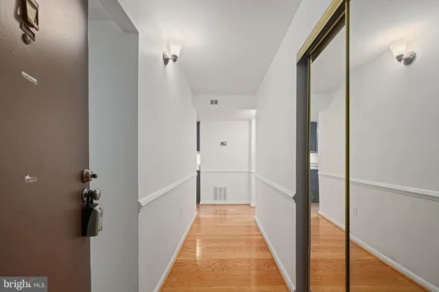 a view of a hallway with wooden floor and staircase