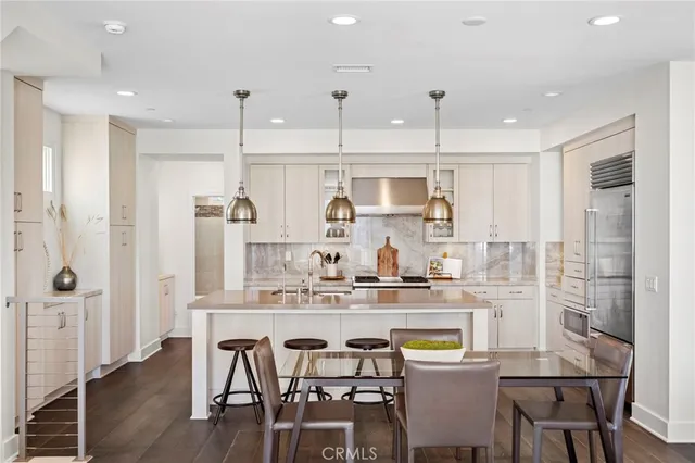 a kitchen with a table chairs stove and wooden floor