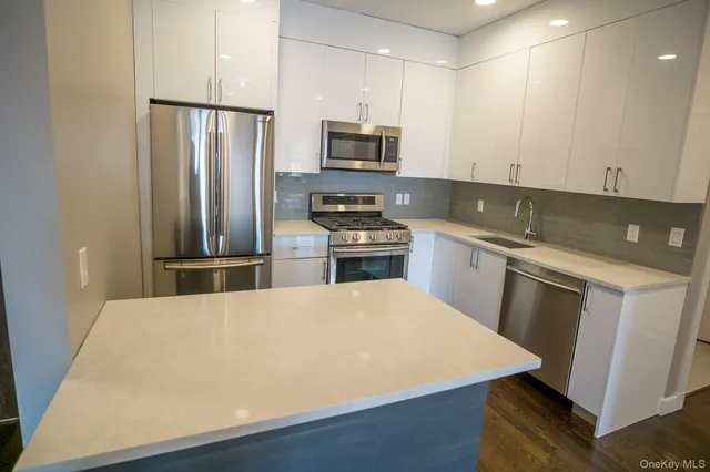 a kitchen with stainless steel appliances a stove refrigerator sink and microwave