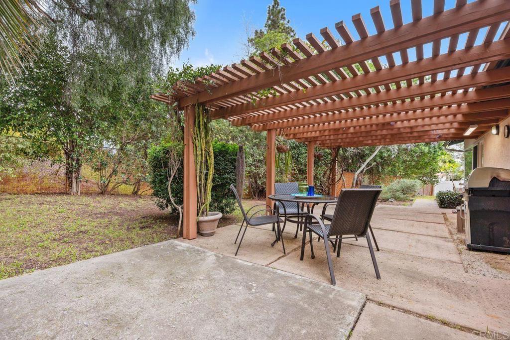 1037 Glenmere Road Vista, CA 92084 - Photo 24 of 36 a view of a patio with table and chairs with wooden floor and fence