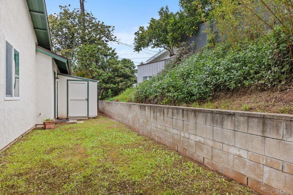 1037 Glenmere Road Vista, CA 92084 - Photo 26 of 36 a view of backyard with small cabin and wooden fence