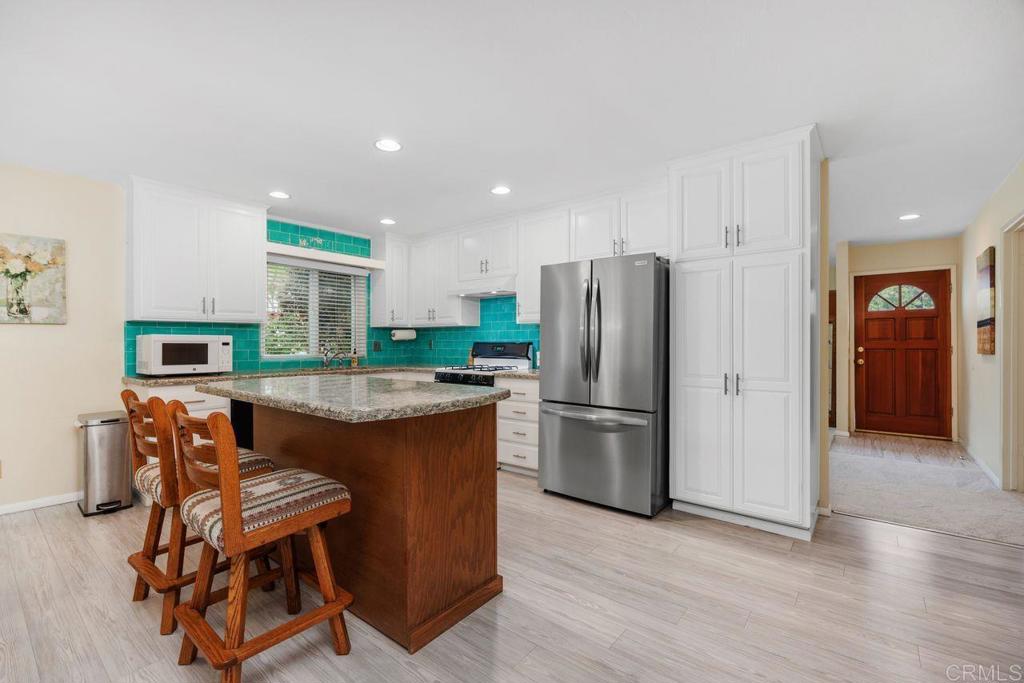 1037 Glenmere Road Vista, CA 92084 - Photo 6 of 36 a view of kitchen with stainless steel appliances granite countertop cabinets and wooden floor