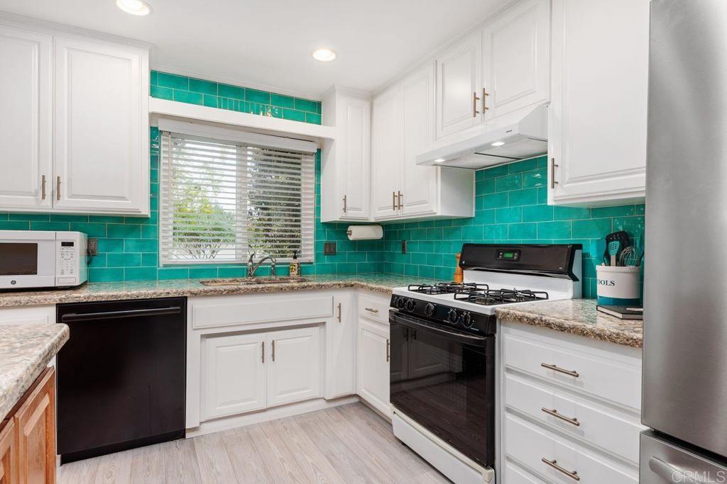 1037 Glenmere Road Vista, CA 92084 - Photo 7 of 36 a kitchen with granite countertop a sink a stove and cabinets