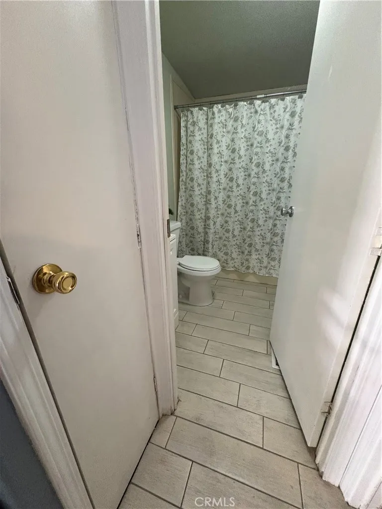 3825 Crestmore Road, Unit 414 Riverside, CA 92501 - Photo 15 of 24 a bathroom with a granite countertop shower and a toilet