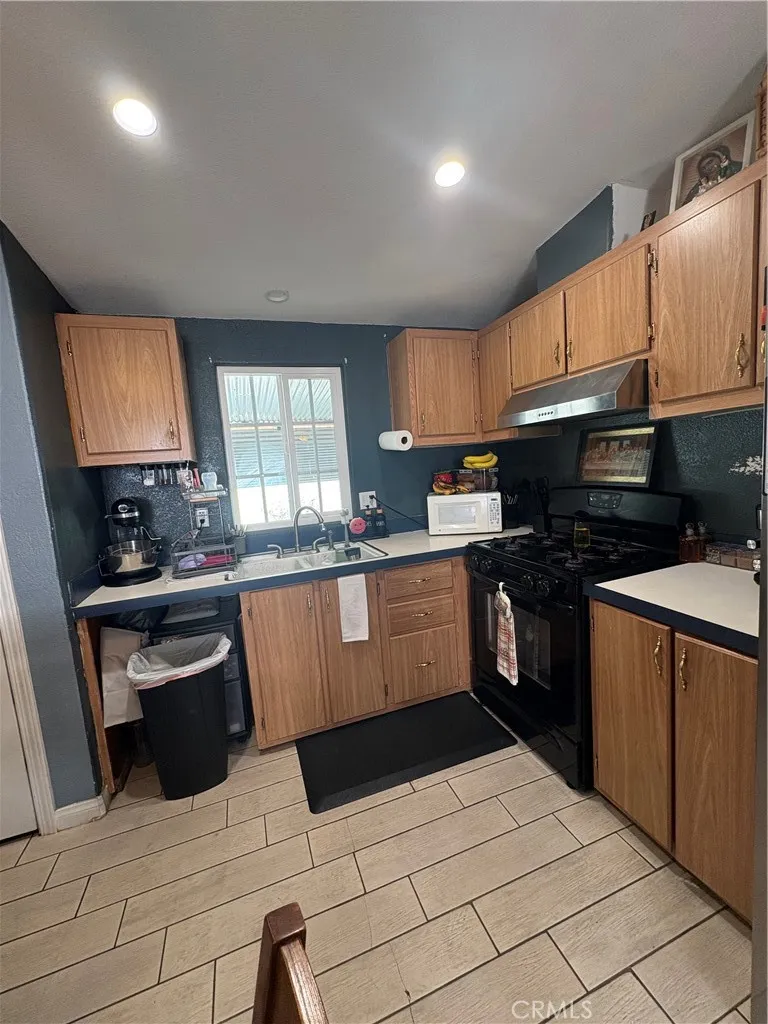 3825 Crestmore Road, Unit 414 Riverside, CA 92501 - Photo 18 of 24 a kitchen with stainless steel appliances kitchen island granite countertop a refrigerator and a stove top oven