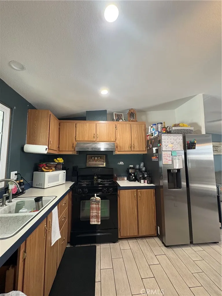 3825 Crestmore Road, Unit 414 Riverside, CA 92501 - Photo 20 of 24 a kitchen with stainless steel appliances granite countertop a stove a sink and a refrigerator
