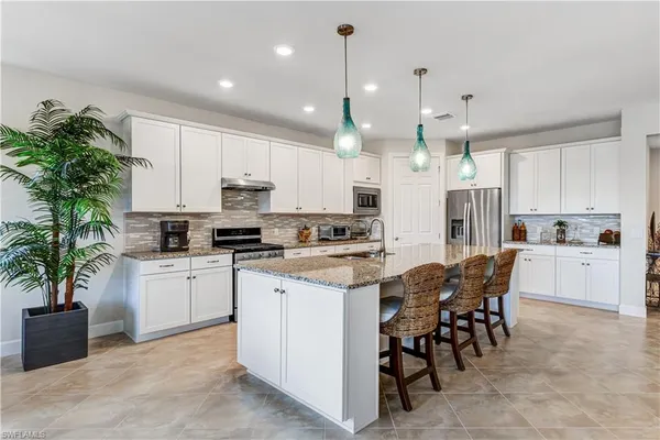 a kitchen with white cabinets and white appliances