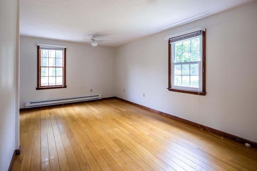 39 Nickerson Road Cotuit, MA 02635 - Photo 11 of 24 an empty room with wooden floor and windows