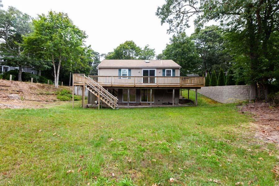 39 Nickerson Road Cotuit, MA 02635 - Photo 16 of 24 a house with a big yard and large trees