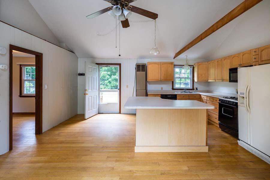 39 Nickerson Road Cotuit, MA 02635 - Photo 6 of 24 a large kitchen with stainless steel appliances a large counter top a refrigerator a stove a sink and a center island